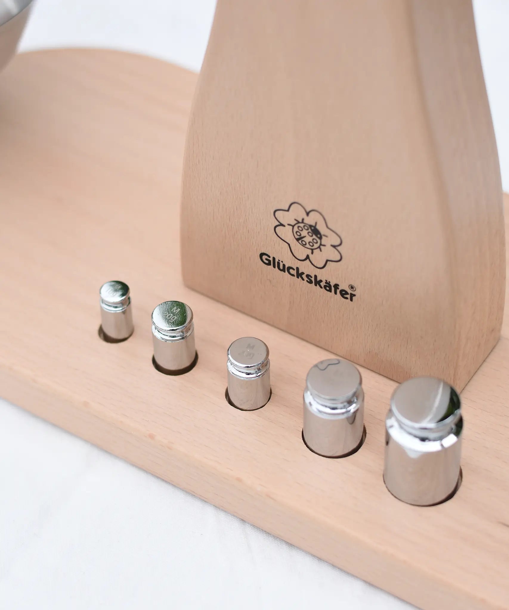 Close up of teh 5 weights included with the Glückskäfer balance with weights children's weighing scales toy.   