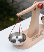 Glückskäfer balance with weights children's weighing scales toy. One side has one weight placed onto it.  