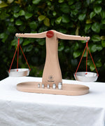 Glückskäfer balance with weights children's weighing scales toy placed on a table outdoors.  
