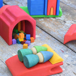 Two Grapat Tomten Nins placed on a red piece from the Gluckskafer castle. They are using it as a bed with a yellow pieces as a pillow that their hats are resting upon.