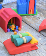 Two Grapat Tomten Nins placed on a red piece from the Gluckskafer castle. They are using it as a bed with a yellow pieces as a pillow that their hats are resting upon.
