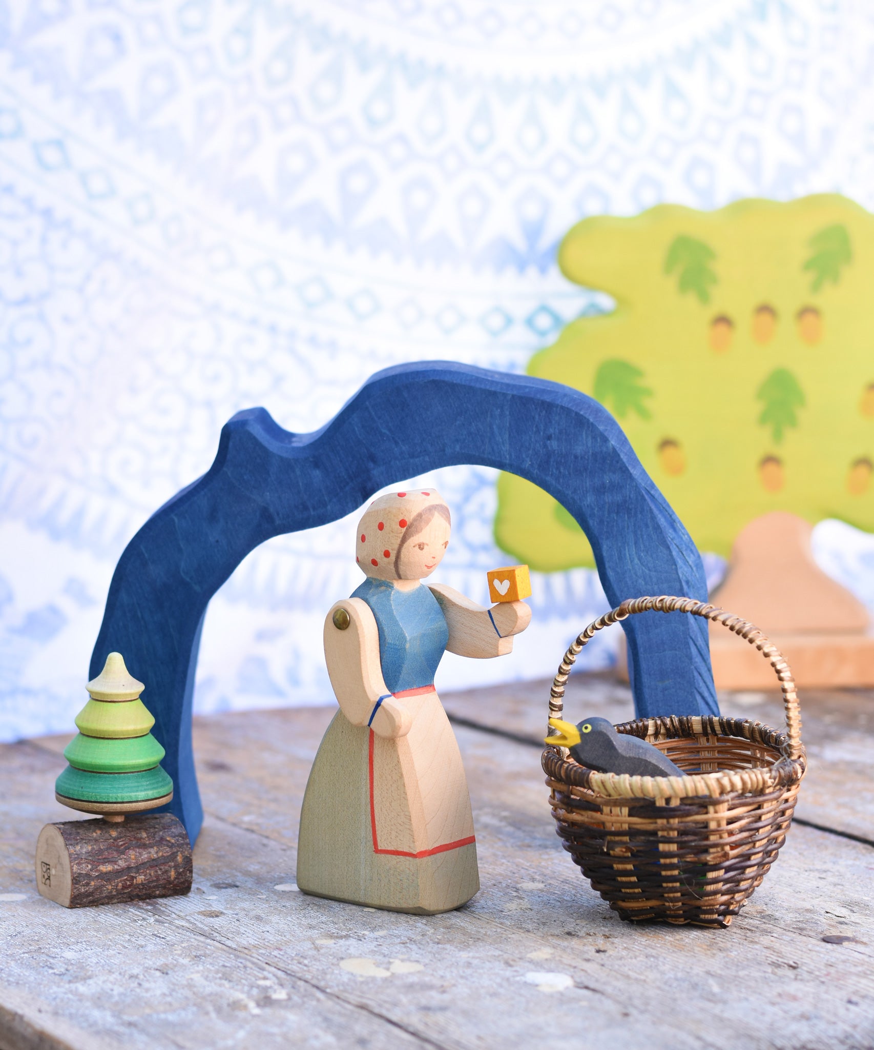 The largest arch from the Glückskäfer Blue Grotto shown in a small world play scene with an Ostheimer female farmwr figure standing next to a Kraul basket with an Ostheimer bird in it. 