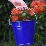 A close up of a Glückskäfer Blue Metal Bucket in a child's hand. 