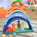 The pieces of the Glückskäfer Blue Sunrise Set stacked up to create a house for Grimm's friends wooden peg dolls.