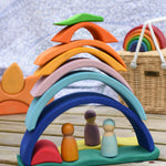 The pieces of the Glückskäfer Blue Sunrise Set stacked up to create a house for Grimm's friends wooden peg dolls.