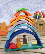 The pieces of the Glückskäfer Blue Sunrise Set stacked up to create a house for Grimm's friends wooden peg dolls.