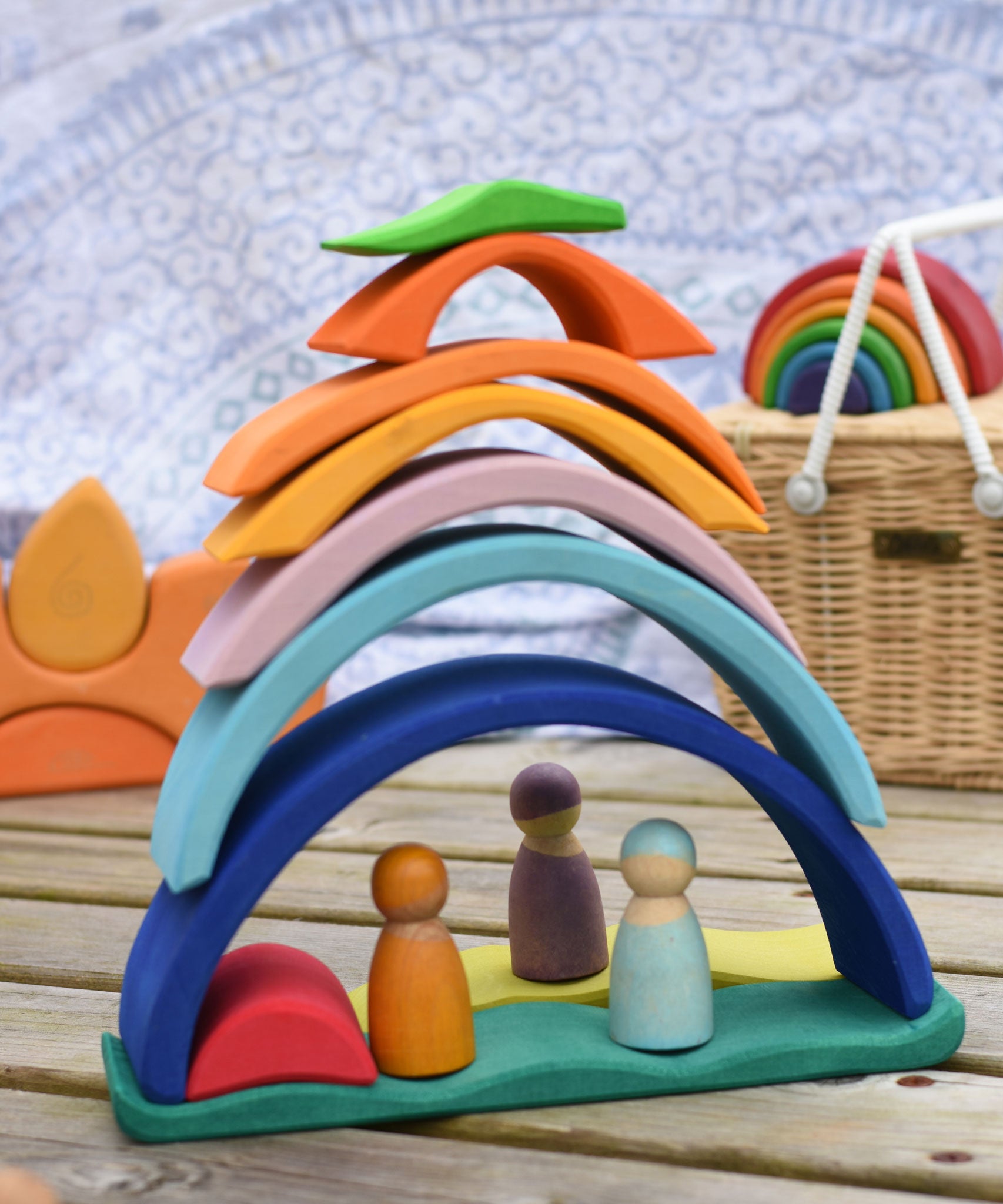 The pieces of the Glückskäfer Blue Sunrise Set stacked up to create a house for Grimm's friends wooden peg dolls.