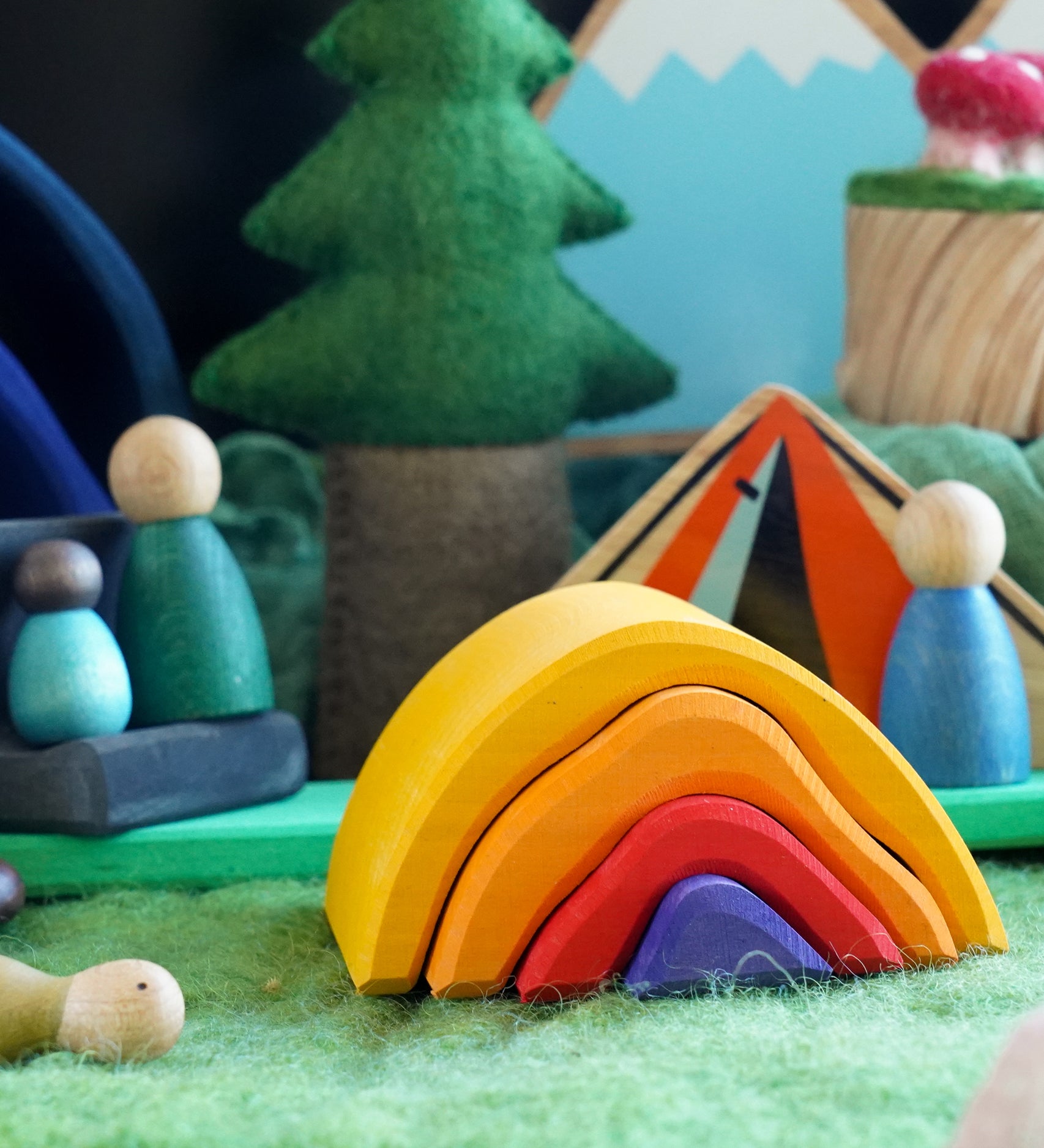 A small world play scene featuring the Glückskäfer Wooden Stacking Bonfire.