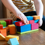 A child stacking blocks from the Glückskäfer 27 Piece Building Blocks Set on top of each other. 