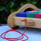 Close up of red pull along string on the front of the Gluckskafer carriage wooden toy block set. 