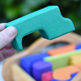 The largest block from the Gluckskafer carriage wooden toy block set in an adult's hand.