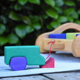 Blocks from the Gluckskafer carriage wooden toy block set used to create a  stack resembling a vehicle.