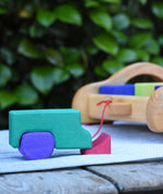 Blocks from the Gluckskafer carriage wooden toy block set used to create a  stack resembling a vehicle.