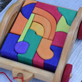Gluckskafer carriage wooden toy block set. A natural wood pull along car with 17 colourful blocks. Close up of blocks.