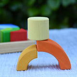 Cylider blocks from the Glückskäfer circles quadrat construction kit balanced on two curved pieces. 
