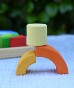 Cylider blocks from the Glückskäfer circles quadrat construction kit balanced on two curved pieces. 