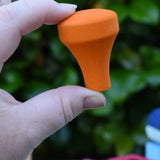 The orange train chimney in an adult's hand from the Glückskäfer colourful shape train wooden toy.