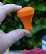 The orange train chimney in an adult's hand from the Glückskäfer colourful shape train wooden toy.