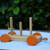 One of the base pieces from the Glückskäfer colourful shape train wooden toy placed on a table outdoors.