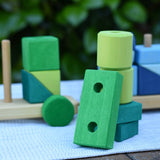 Green blocks from the Glückskäfer colourful shape train wooden toy stacked up on top of each other.