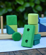 Green blocks from the Glückskäfer colourful shape train wooden toy stacked up on top of each other.