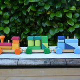 Glückskäfer colourful shape train wooden toy placed on a wooden surface outdoors.
