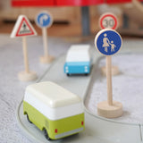 Gluckskafer wooden walking pedestrian traffic sign next to a play road with Candylab cars and other common traffic signs in the background