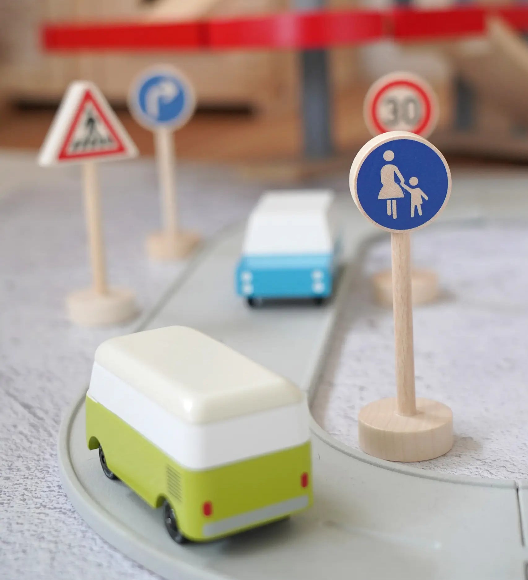 Gluckskafer wooden walking pedestrian traffic sign next to a play road with Candylab cars and other common traffic signs in the background