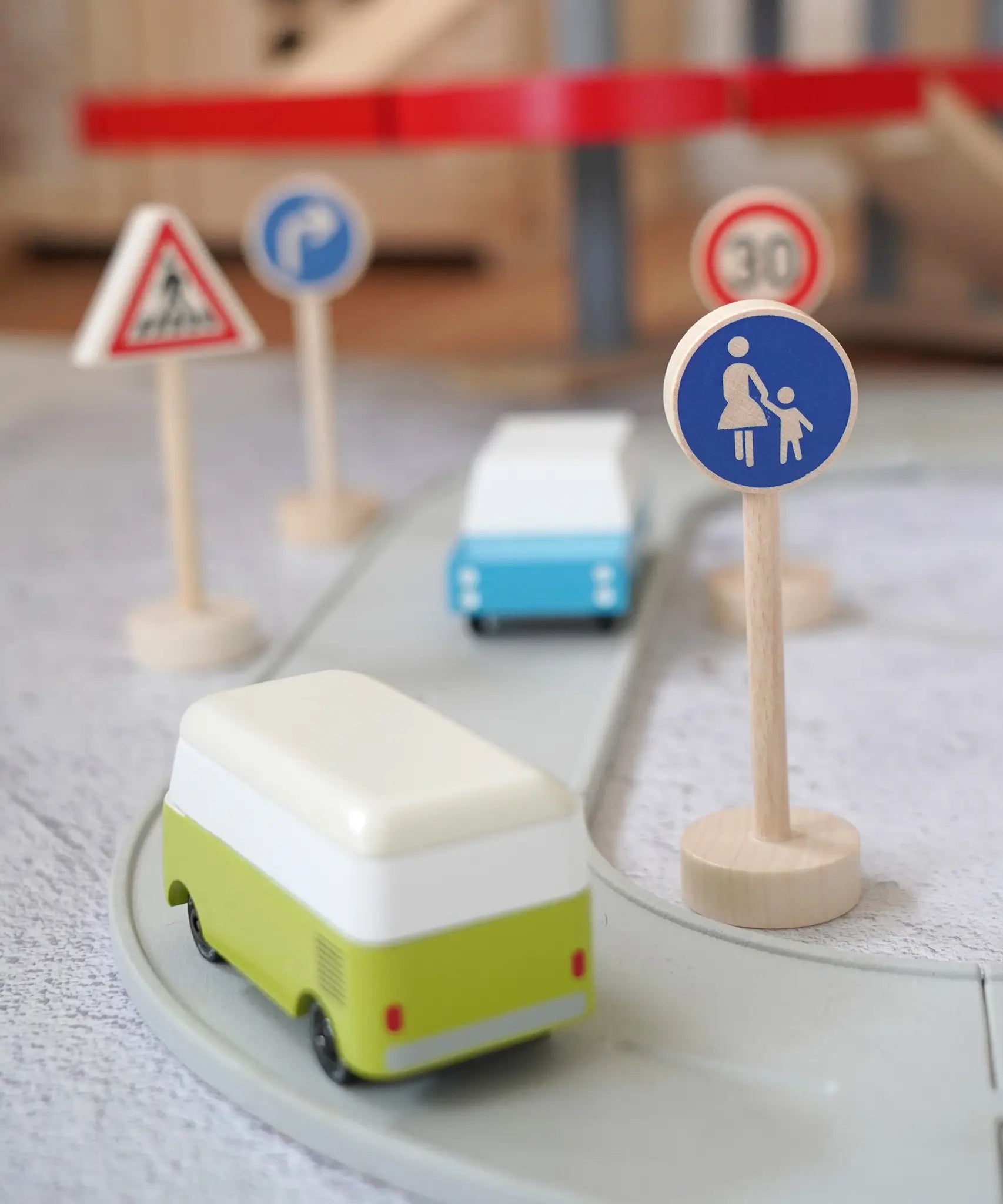 Gluckskafer wooden walking pedestrian traffic sign next to a play road with Candylab cars and other common traffic signs in the background