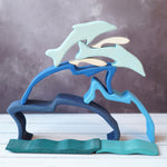 The Gluckskafer Stacking Dolphin taken apart and stacked up on a wooden surface. 