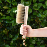 Glückskäfer wooden dust brush with natural horse hair bristles in a child's hand.