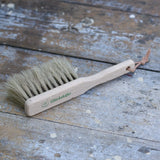 Glückskäfer wooden dust brush with natural horse hair bristles placed on a wooden surface.