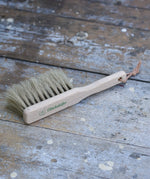 Glückskäfer wooden dust brush with natural horse hair bristles placed on a wooden surface.