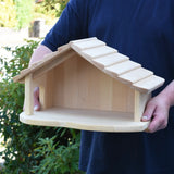Gluckskafer farm & nativity stable wooden toy building in an adult's hands.