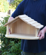 Gluckskafer farm & nativity stable wooden toy building in an adult's hands.
