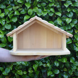 Gluckskafer farm & nativity stable wooden toy building balanced on an adult's arm.