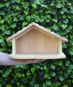 Gluckskafer farm & nativity stable wooden toy building balanced on an adult's arm.