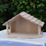 Gluckskafer farm & nativity stable wooden toy building placed on a cloth covered table outdoors.