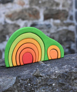 Glückskäfer Green 8 Piece Arch House shown placed on a stone wall outdoors.