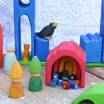A small world play scene created using the Gluckskafer castle set along with Grapat Tomten wooden peg dolls and other wooden toy figures.