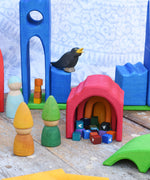 A small world play scene created using the Gluckskafer castle set along with Grapat Tomten wooden peg dolls and other wooden toy figures.