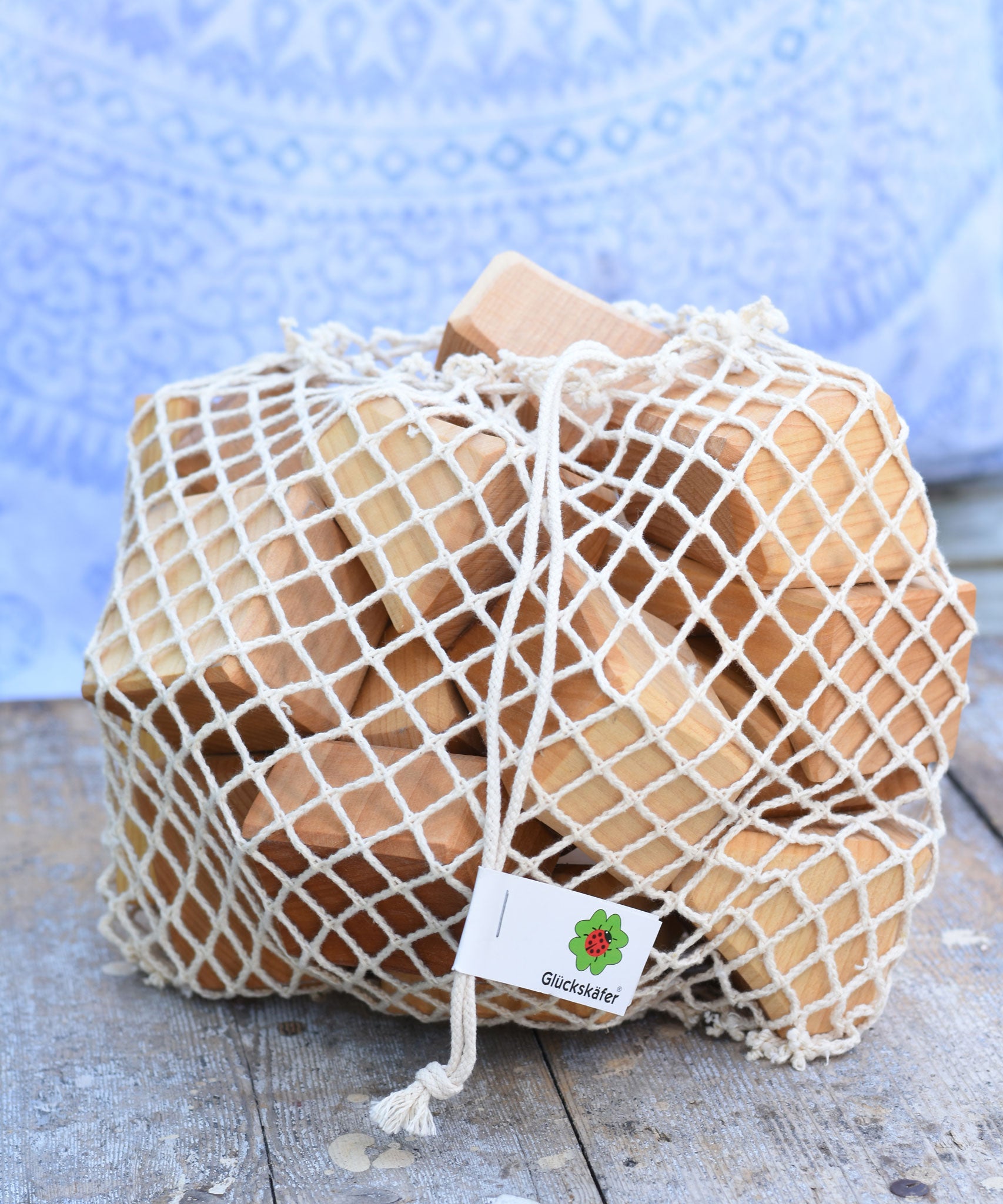 The Glückskäfer 17 Large Natural Blocks Set shown in their netting storage bag.