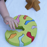 The tree part from the Glückskäfer light green wooden bird tree puzzle stacker toy placed flat on a table.