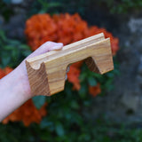 A bridge piece from the Glückskäfer Marble Track Bridge and Tunnel Set in a child's hand.