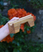 A bridge piece from the Glückskäfer Marble Track Bridge and Tunnel Set in a child's hand.