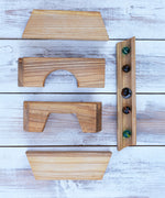 The pieces from the Glückskäfer Marble Track Bridge and Tunnel Set laid out on a wooden surface.