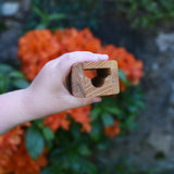 A tunnel piece from the Glückskäfer Marble Track Bridge and Tunnel Set in a child's hand.