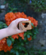 A tunnel piece from the Glückskäfer Marble Track Bridge and Tunnel Set in a child's hand.