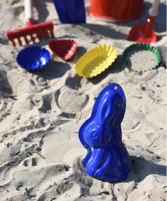A Glückskäfer Metal Rabbit Sand Mould placed on the sand on a beach