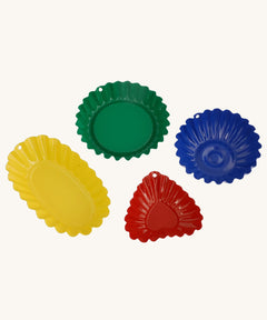 Glückskäfer Metal Sand Mould Set consists of 4 colourful sand moulds with fluted, scalloped edges that makes them ideal for creating detailed shapes in the sand. There is 
 a red heart, a green shallow circle, a deep blue circle and a yellow oval.